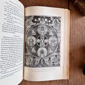 May include: A black and white illustration of a mandala with multiple circles and figures. The text "The Great Mandala of the Peaceful Deities" is printed below the image.