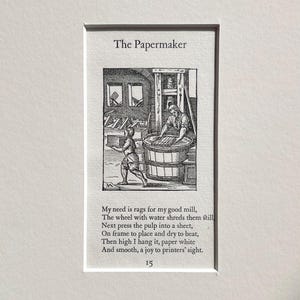May include: A framed black and white print titled "The Papermaker." The image depicts a historical scene of papermaking, with figures working around a large vat and a wheel. Text below describes the papermaking process.