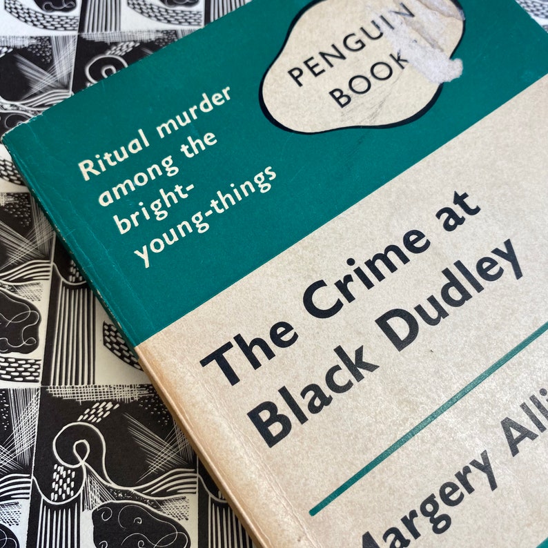 Puede incluir: Un libro de bolsillo Penguin con una cubierta verde y texto blanco. El t&iacute;tulo es "The Crime at Black Dudley" de Margery Allingham. El libro trata sobre un asesinato ritual entre los j&oacute;venes brillantes.