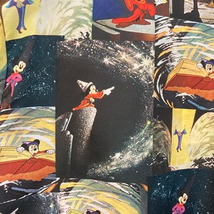 May include: A colorful fabric with a repeating pattern of Mickey Mouse in different poses. The fabric features a dark blue background with stars and a swirling pattern. Mickey Mouse is depicted as a sorcerer, a magician, and a regular mouse.