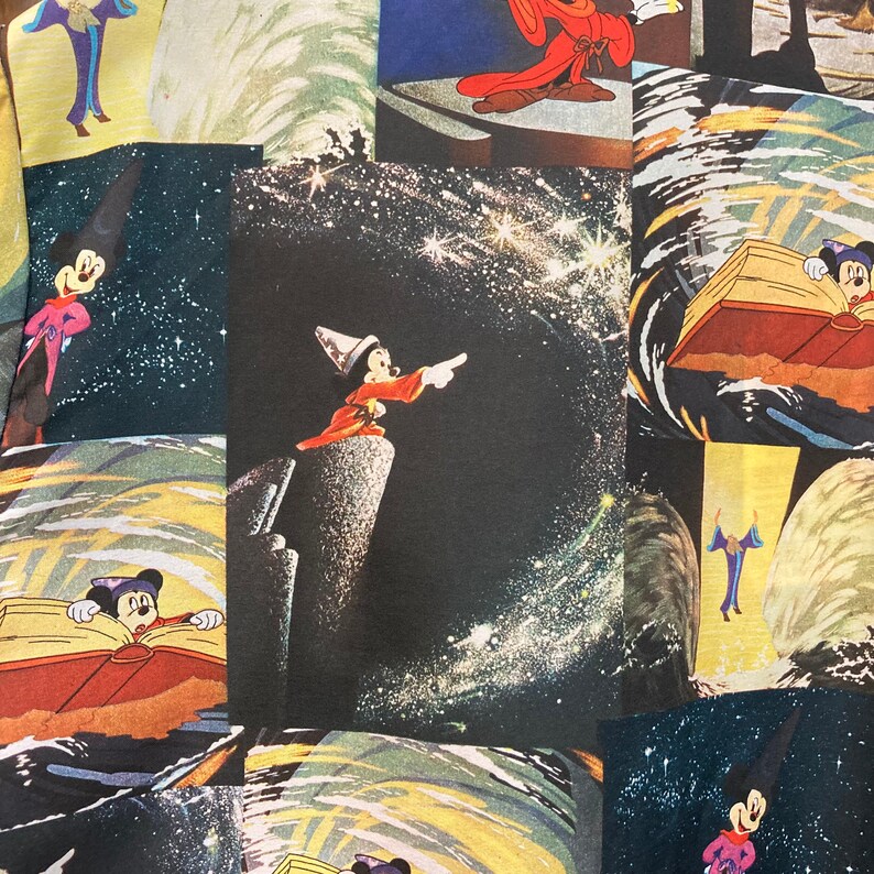 May include: A colorful fabric with a repeating pattern of Mickey Mouse in different poses. The fabric features a dark blue background with stars and a swirling pattern. Mickey Mouse is depicted as a sorcerer, a magician, and a regular mouse.