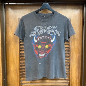 May include: A black t-shirt with a red devil graphic and the text "BLACK SABBATH" in white letters.