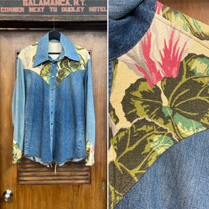 Puede incluir: Una camisa vaquera azul con paneles de tela floral en los hombros, el canesú y los puños. La tela floral es de fondo beige con hojas verdes y flores rosas.