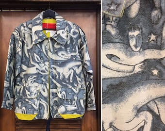 May include: A blue and white patterned jacket with a zipper closure and yellow accents. The pattern features abstract figures and stars. The jacket is hanging on a wooden door with a sign that reads "SALAMANCA, N.Y. CORNER NEXT TO DUDLEY HOTEL."