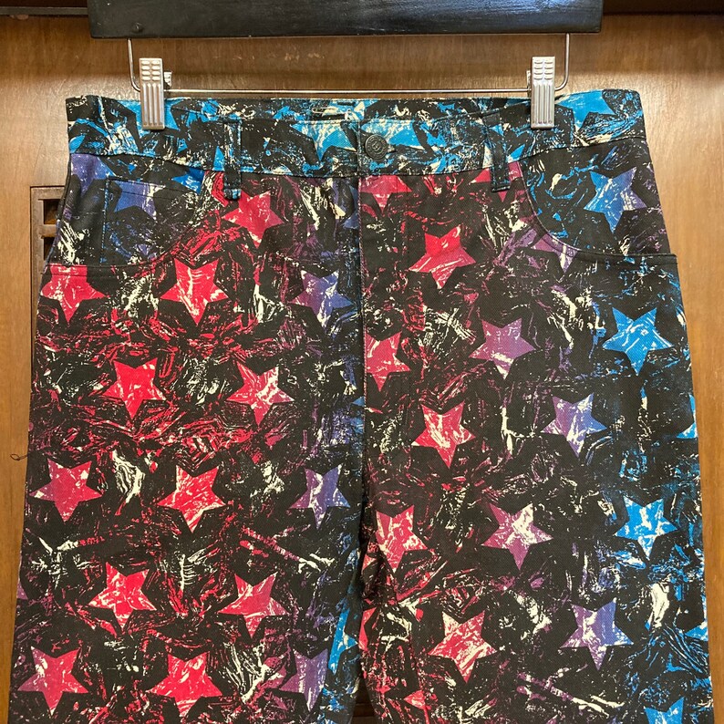 May include: A pair of blue, red, and white star-patterned denim shorts. The stars are printed in a distressed, abstract style.