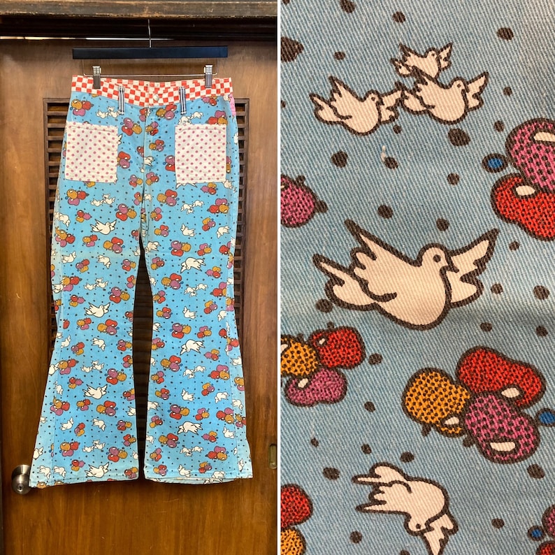 May include: A pair of blue bell bottom jeans with a white dove and colorful balloon pattern. The jeans have red and white checkered waistband and red and white polka dot pockets.