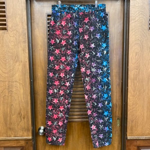 May include: A pair of blue, pink, and black patterned pants with a star design.