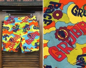 May include: A pair of colorful shorts with a psychedelic pattern featuring the words "Peace", "Love", and "Grobb".