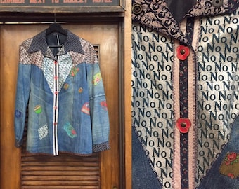 May include: A blue denim jacket with a patchwork design. The jacket has a collar, long sleeves, and a button-up front. The fabric is decorated with various patterns, including floral prints, geometric shapes, and a repeating "No" pattern. The jacket has a vintage aesthetic.