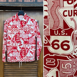 May include: A red and white long-sleeved button-up shirt with a pattern of various road signs, including "Stop", "Yield", "Curve", and "U.S. 66".