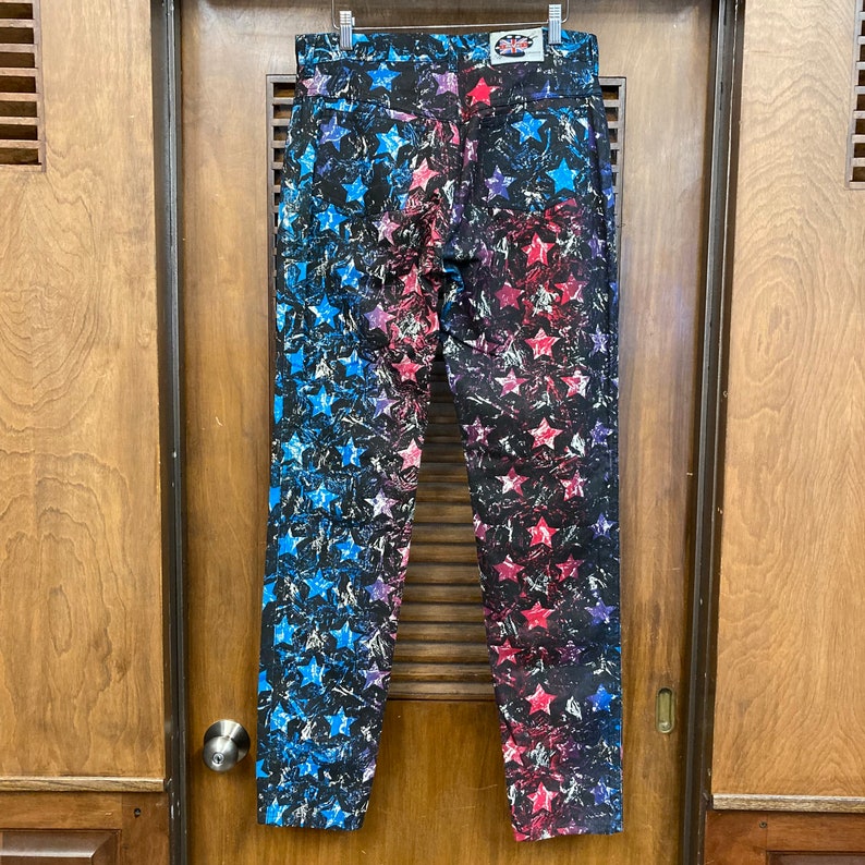 May include: A pair of blue and red jeans with a star pattern. The jeans have a faded look and are made of a soft, comfortable material.
