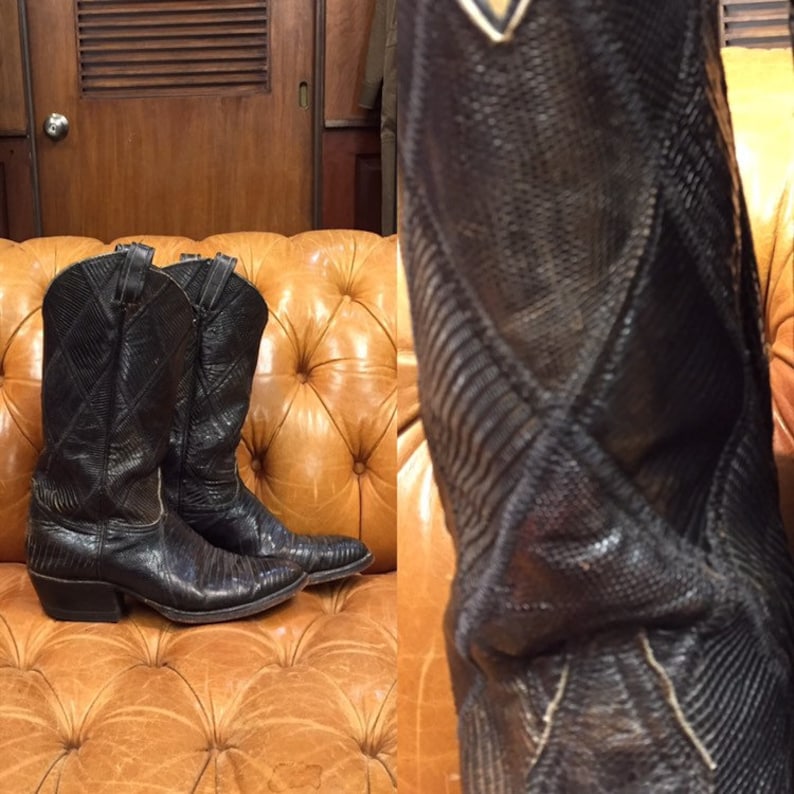 Pu&ograve; includere: Un paio di stivali da cowboy in pelle nera con motivo a pelle di serpente. Gli stivali hanno una punta a punta e un tacco alto.