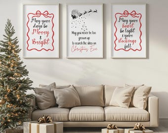 May include: Three framed prints with Christmas messages in red, set against a white background. The prints feature festive text and imagery of Santa's sleigh. A decorated Christmas tree and wrapped gifts are in the foreground.
