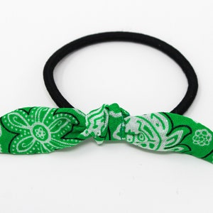 Puede incluir: Coleta de pelo de tela con estampado verde y blanco con banda el&aacute;stica negra.