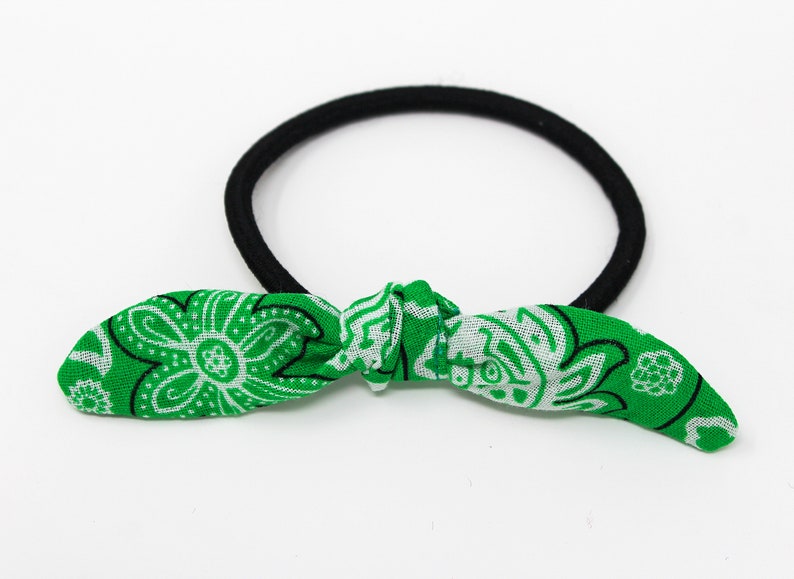 Puede incluir: Coleta de pelo de tela con estampado verde y blanco con banda el&aacute;stica negra.
