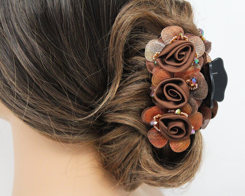 Może przedstawiać: Brązowa spinka do włos&oacute;w z trzema brązowymi kwiatami z tkaniny i brązowymi i złotymi koralikami.