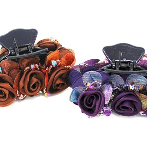 Może przedstawiać: Dwa spinki do włos&oacute;w z kwiatowym wzorem. Jedna spinka jest brązowa z brązowymi kwiatami, a druga jest fioletowa z fioletowymi kwiatami.