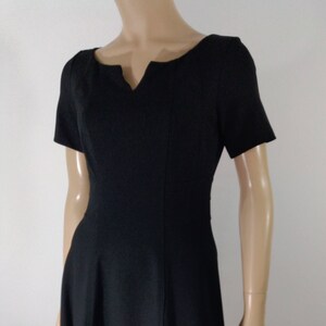 May include: A black short-sleeved dress with a v-neckline and a flared skirt.