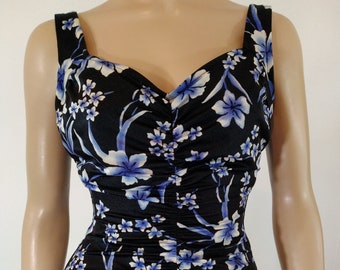 May include: A black one-piece swimsuit with a blue and white floral print. The swimsuit has a sweetheart neckline and thin straps.
