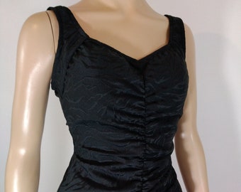 May include: A black one-piece swimsuit with a ruched front and a textured pattern.