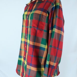 May include: A long-sleeved button-down shirt with a plaid pattern in shades of red, green, yellow, and brown.