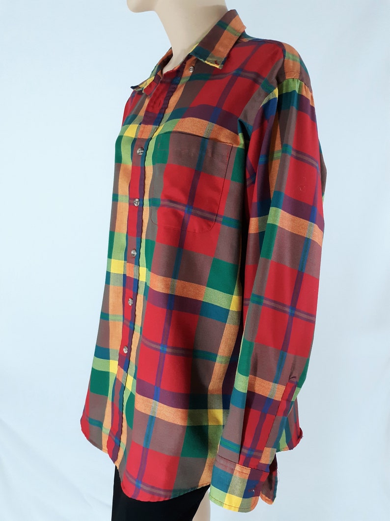 May include: A long-sleeved button-down shirt with a plaid pattern in shades of red, green, yellow, and brown.