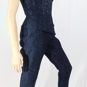 May include: A navy blue strapless jumpsuit with a lace pattern and a beaded bodice.