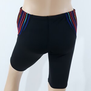 May include: Black swim shorts with a colorful striped design on the sides.