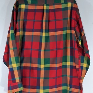 May include: A long-sleeved button-down shirt with a plaid pattern in shades of red, orange, yellow, green, and brown.