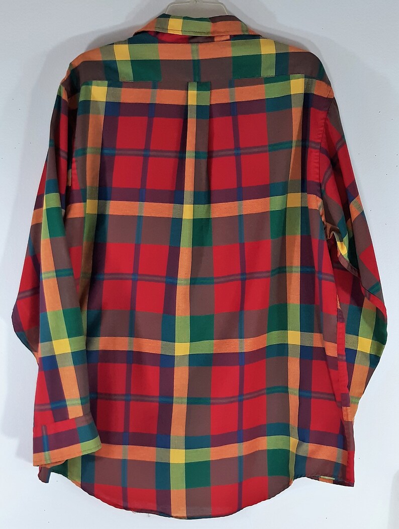May include: A long-sleeved button-down shirt with a plaid pattern in shades of red, orange, yellow, green, and brown.