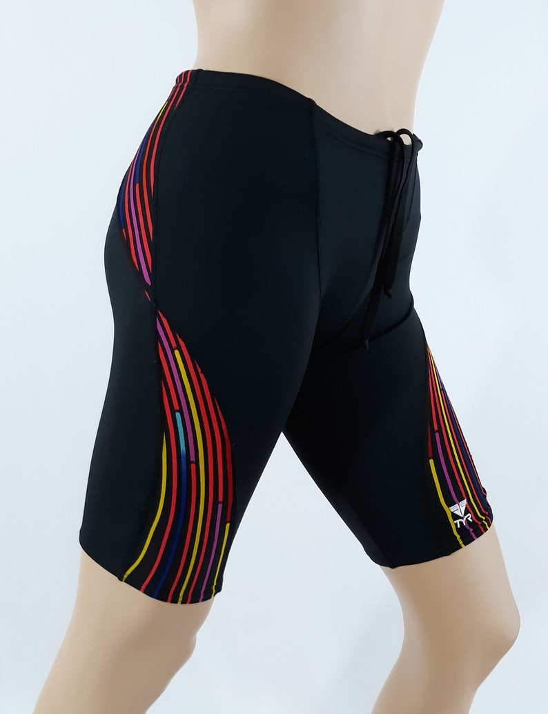 May include: Black swim shorts with a colorful stripe design on the side. The shorts have a drawstring waist and a small logo on the right leg.