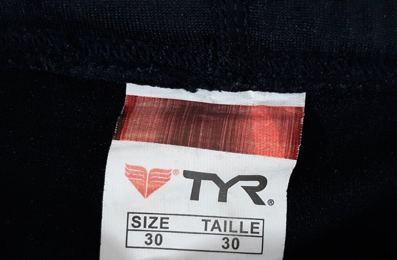 May include: A white TYR brand tag with a red logo and the text "SIZE 30" and "TAILLE 30".