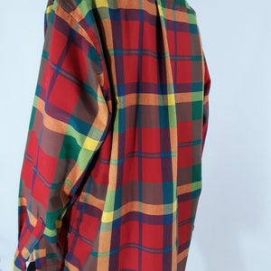 May include: A long-sleeved button-down shirt with a plaid pattern in red, orange, yellow, green, and brown.