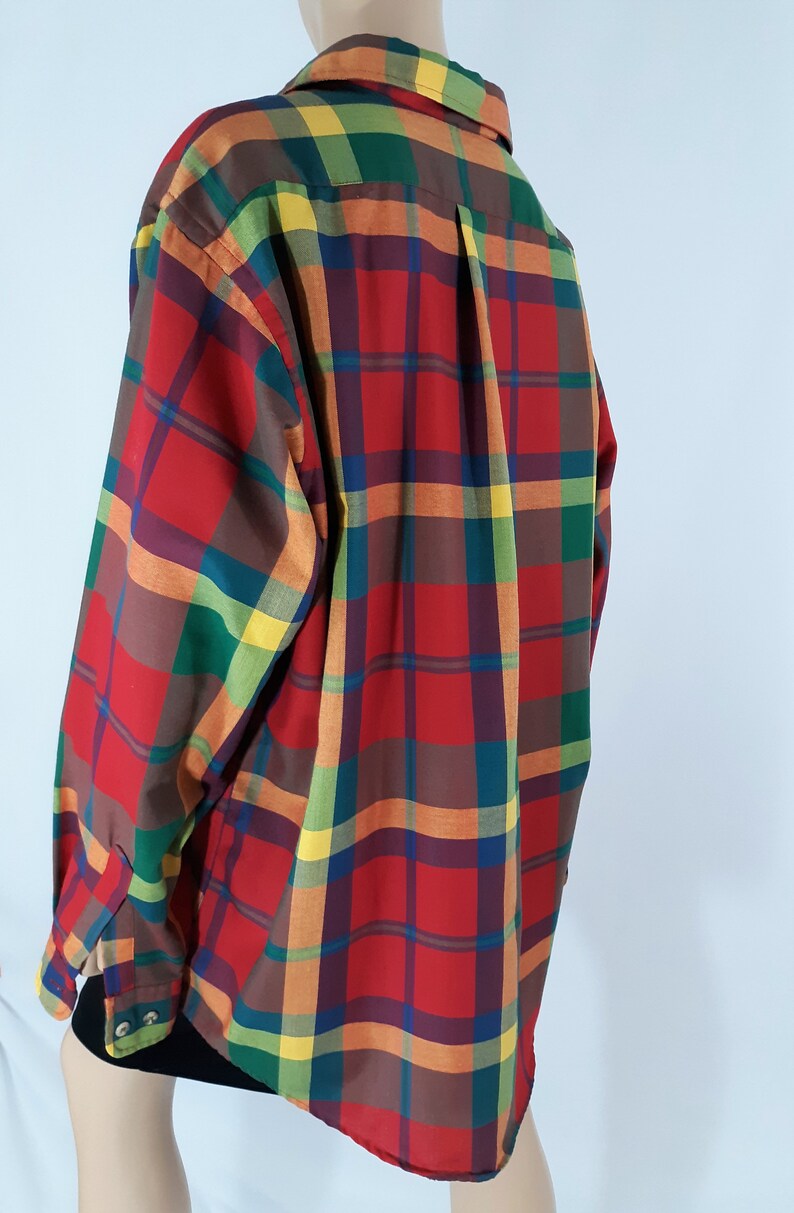 May include: A long-sleeved button-down shirt with a plaid pattern in red, orange, yellow, green, and brown.