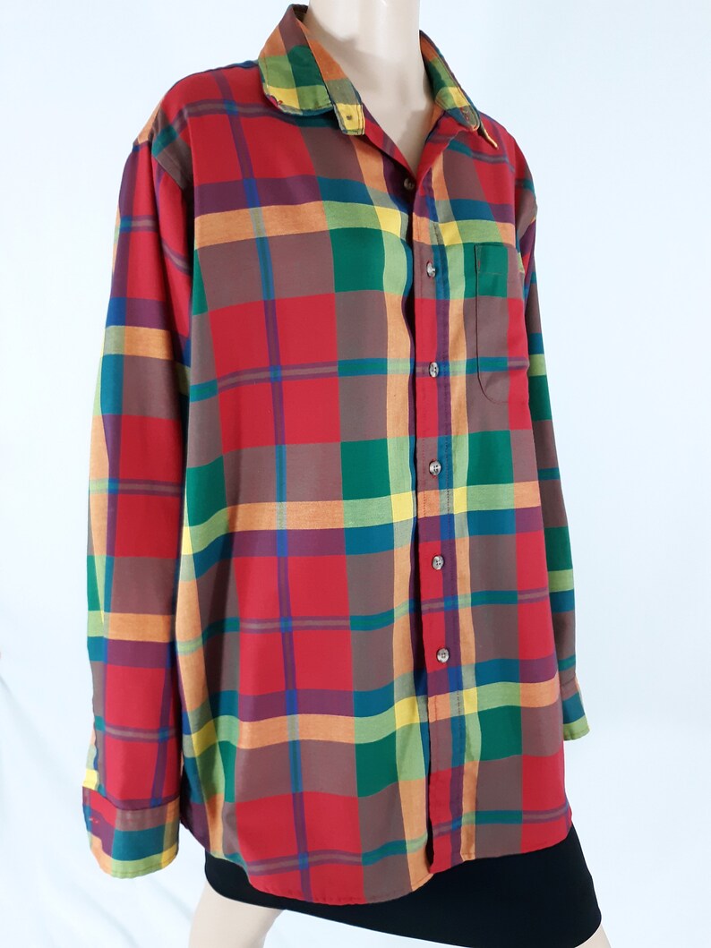 May include: A long-sleeved button-down shirt with a plaid pattern in shades of red, green, orange, and yellow.