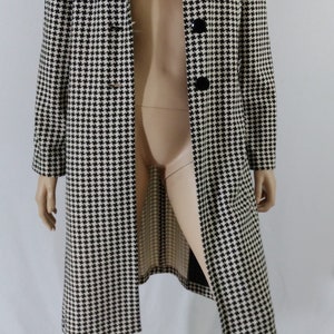 May include: A long black and white houndstooth patterned coat with black buttons.