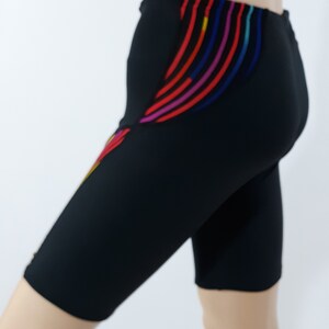 May include: Black athletic shorts with colorful stripes on the side.