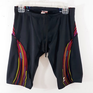 May include: Black swim trunks with a colorful geometric pattern on the sides. The trunks have a drawstring waist.