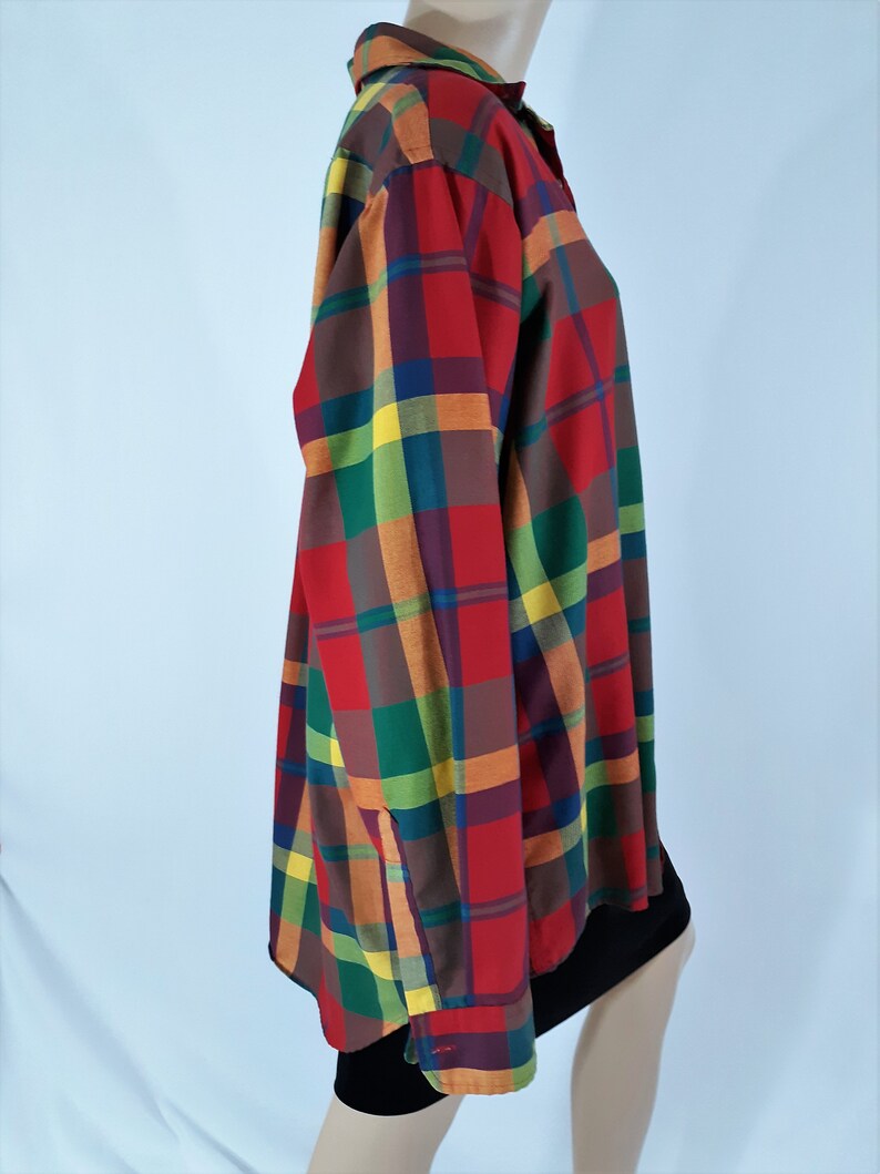 May include: A long-sleeved button-down shirt with a multi-colored plaid pattern. The shirt features red, green, yellow, and brown plaid squares.