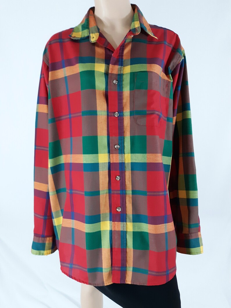 May include: A long-sleeved button-down shirt with a plaid pattern in shades of red, green, yellow, and brown.
