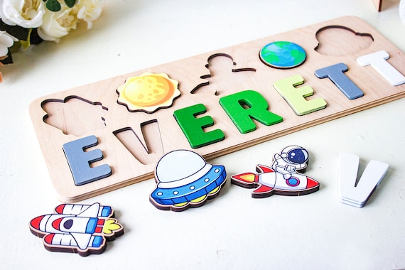 Astronaut-themed wooden name puzzle with planets and space scene — the 27 favorites signal real demand and the space theme lifts it way above generic name puzzles.