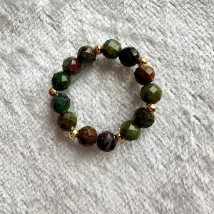 May include: A set of three ceramic mugs with a speckled, matte finish in cream, light grey, and dark grey. Each mug has a simple, modern design and a rounded handle. Ideal for tea or coffee.