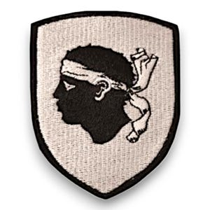 Peut inclure: Un écusson brodé blanc en forme de bouclier avec une silhouette noire d'une tête de personne portant un bandeau. Le patch est un symbole de la Corse.