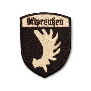 May include: A black and tan embroidered patch with a stylized deer head and the text "Ostpreußen" in black.
