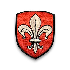 Puede incluir: Parche bordado con un diseño heráldico de flor de lis. El parche en forma de escudo tiene un fondo rojo y un emblema de flor de lis de color crema. El emblema está delineado en negro y el parche tiene un borde negro.