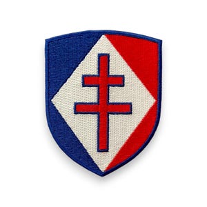 May include: Shield-shaped embroidered patch with a blue border, white diamond, and red sections. A red double cross is centered on the white diamond. Suitable for attaching to clothing or accessories.