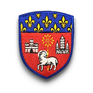 Può includere: Una toppa ricamata blu e rossa con uno stemma. Lo stemma presenta un agnello bianco, un castello, una chiesa e un giglio dorato.