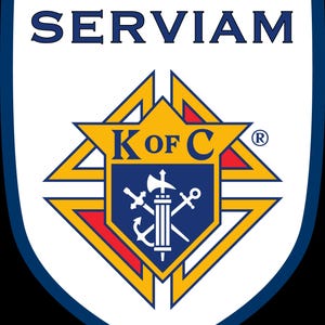 Op de afbeelding: Een schildvormig embleem met het woord SERVIAM in donkerblauwe letters bovenaan. Daaronder ligt een gele stervorm over een blauw schild met de tekst K OF C en een witte afbeelding van een fasces, een anker en een zwaard in het midden.