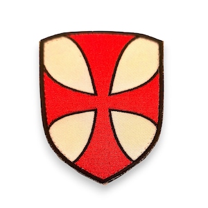 Pode incluir: Um patch em forma de escudo com um design de cruz vermelha e quatro segmentos creme. A cruz está centrada em um fundo vermelho, delineada em preto. O patch tem uma borda preta, adequado para roupas ou acessórios.