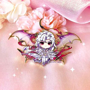 May include: A gold-colored enamel pin featuring a chibi-style character with white hair, red eyes, and purple and gold wings. The character is wearing a white and purple outfit. The pin has a detailed design with a glossy finish.